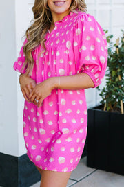 a woman wearing a pink polka dot dress