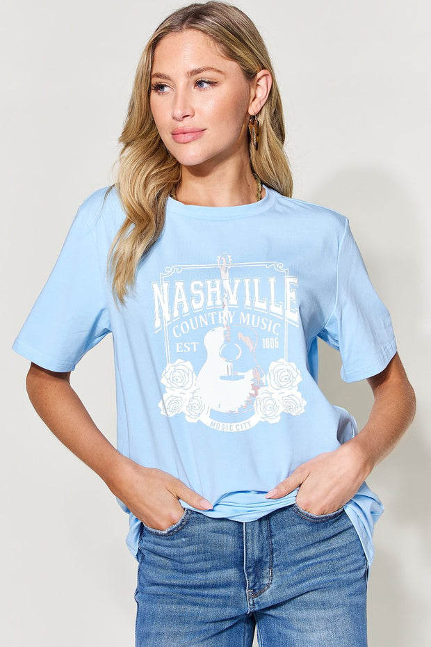 a woman wearing a blue nashville t - shirt