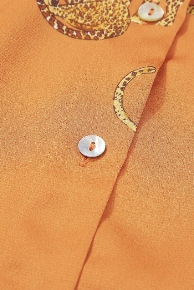 a close up of a button on an orange shirt