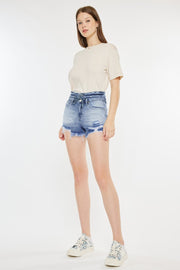 a woman in a white t - shirt and denim shorts