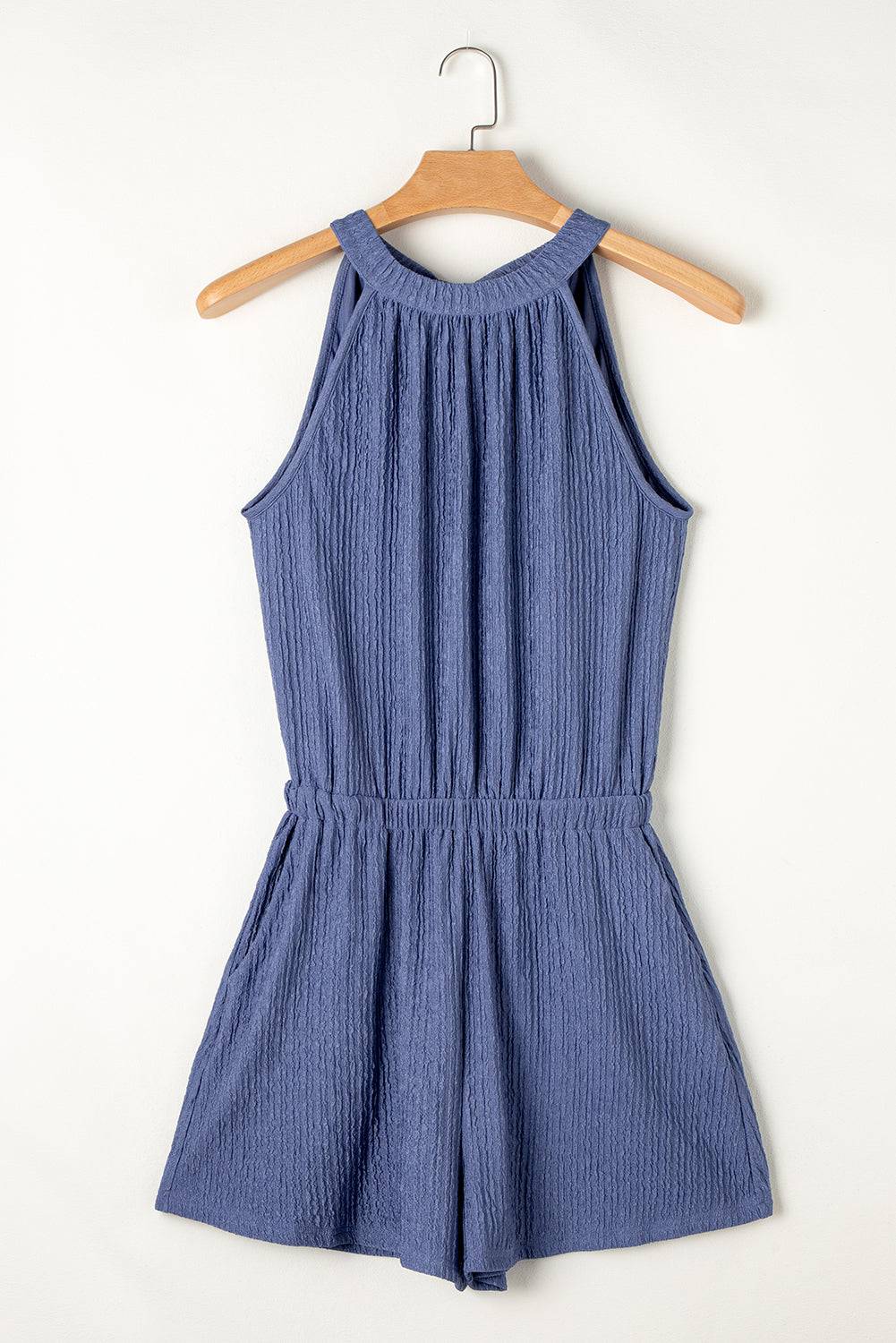 a blue romper playsuit hangs on a hanger