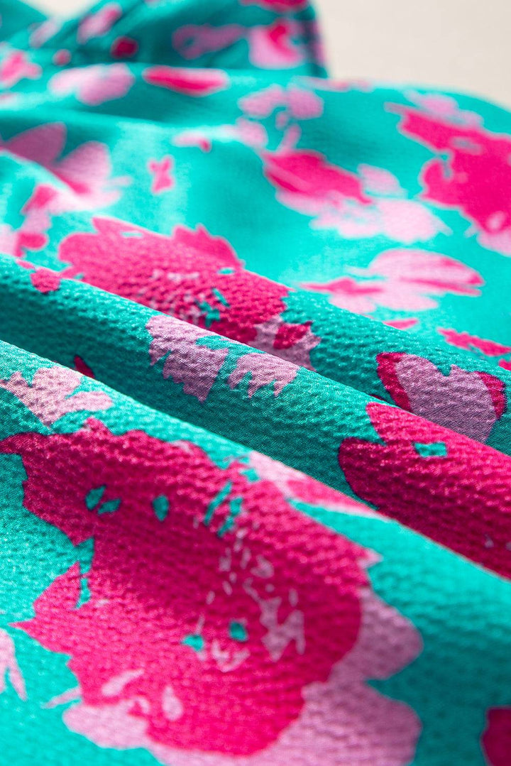 a blue and pink flowered fabric with pink flowers on it