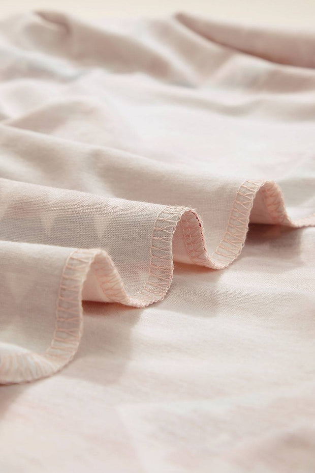a close up of a pink bed spread