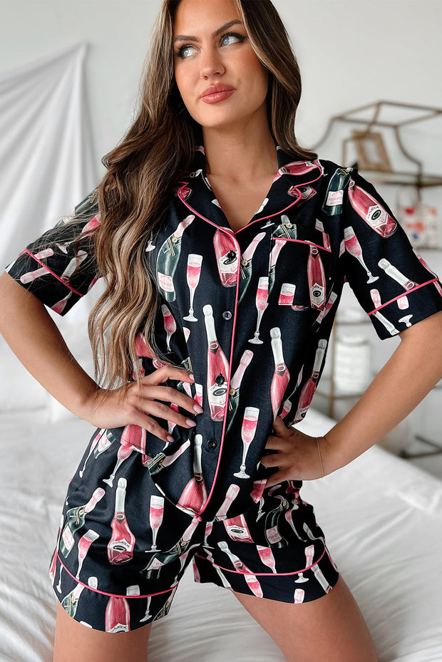 a woman posing on a bed wearing a black and pink pajamasuit