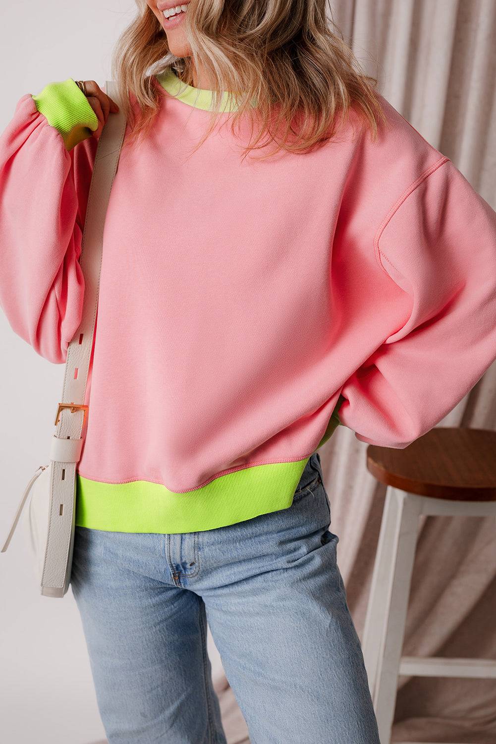 a woman wearing a pink sweater and jeans