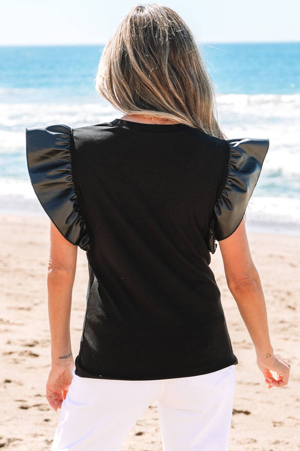Back view of Black Leather Ruffle Sleeve Patchwork Round Neck Blouse showing ruffled faux leather detail, available at Faith & Co. Boutique.
