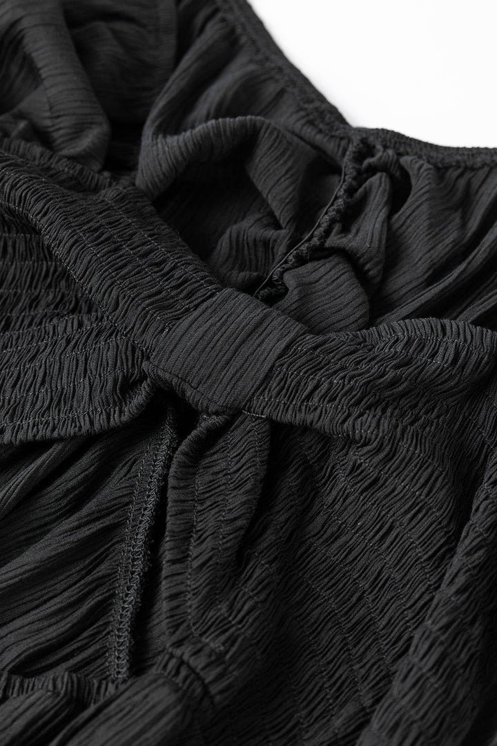 a close up of a black dress on a white surface