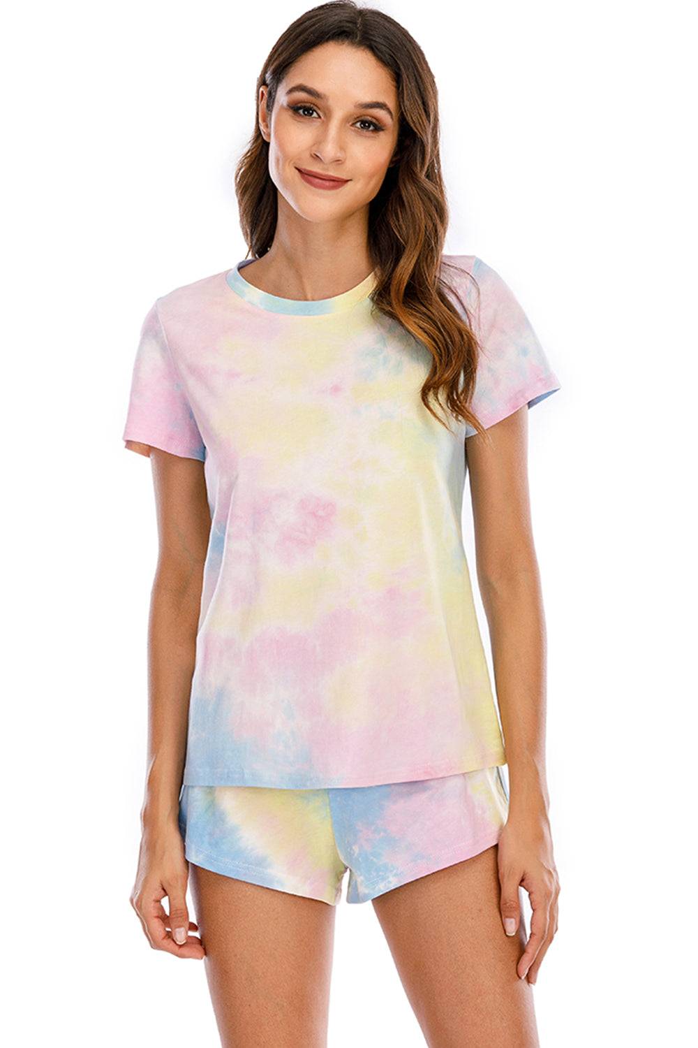 a woman wearing a tie dye shirt and shorts