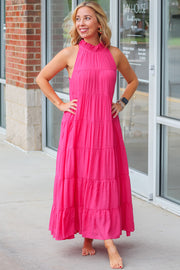 a woman standing in front of a building wearing a pink dress