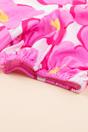 a close up of a pink and yellow flowered blanket