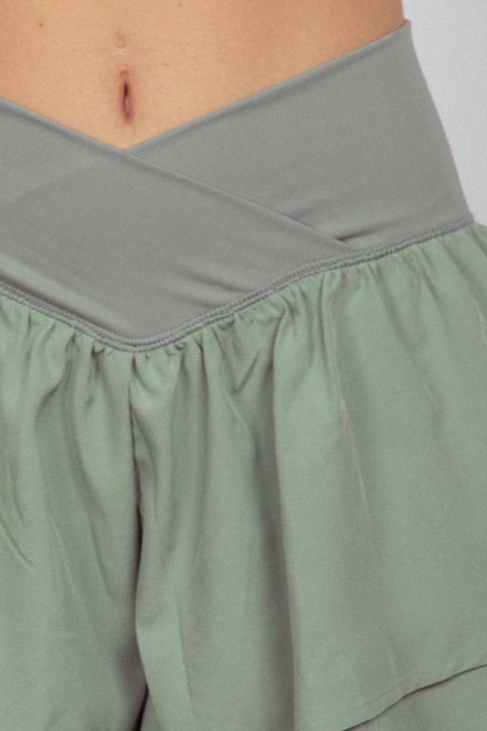 a close up of a woman's stomach wearing a green skirt