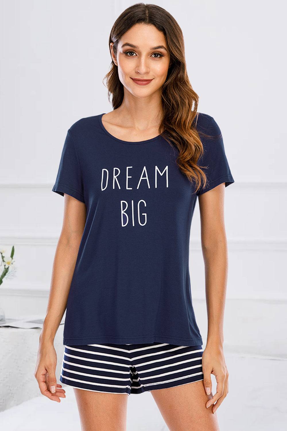 a woman wearing a pajamasuit with the words dream big printed on it
