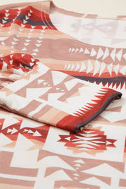 a red and white blanket laying on top of a bed