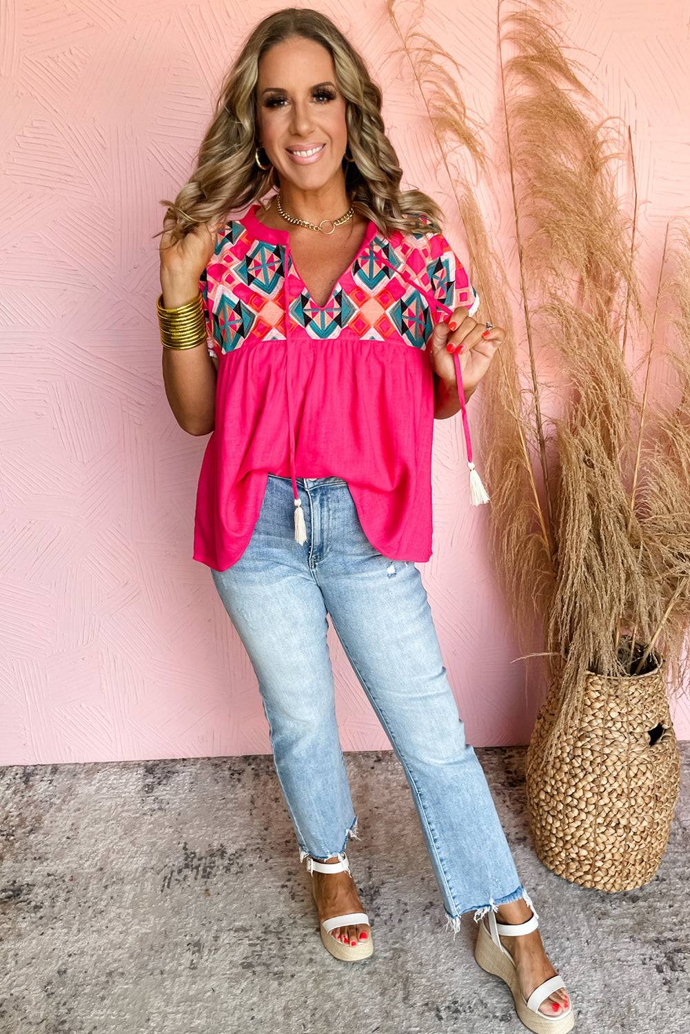 a woman standing in front of a pink wall