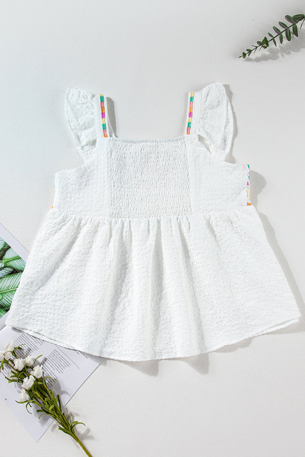 a baby girl's white dress on a table