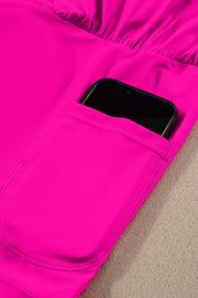 a cell phone sticking out of the pocket of a pink jacket