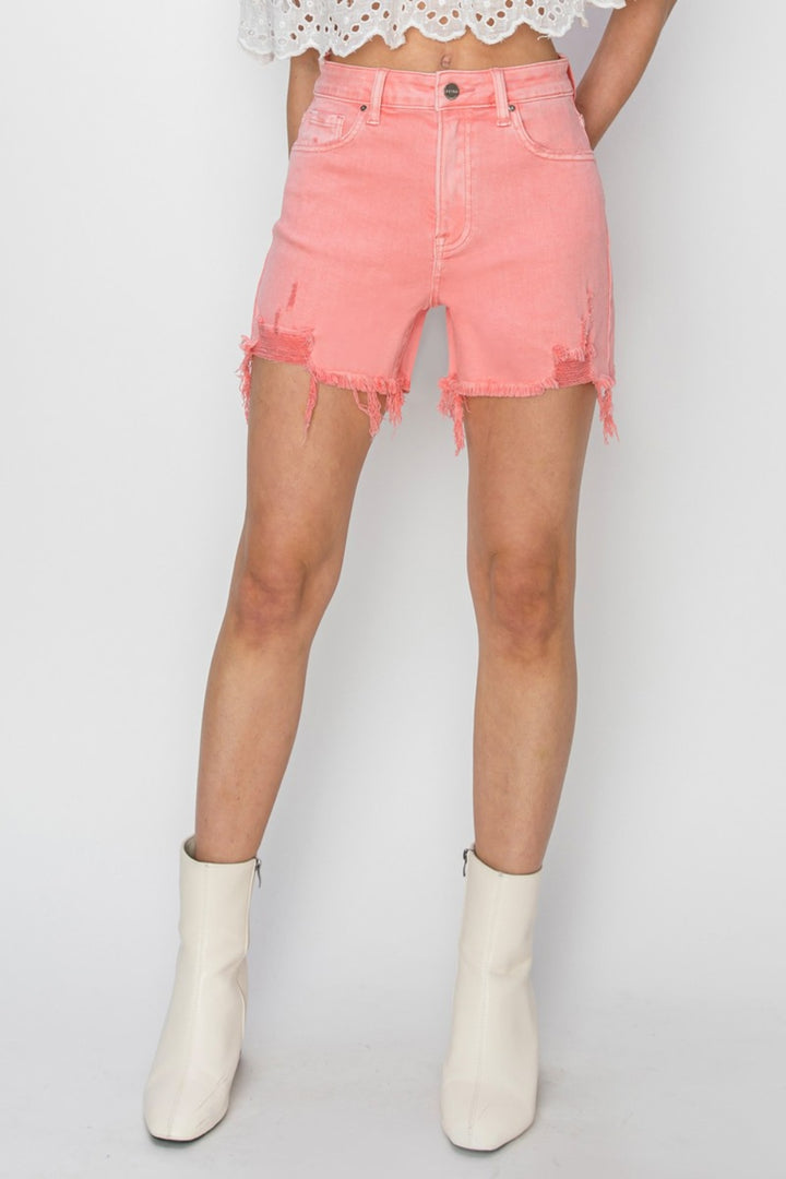 a woman wearing a white top and pink shorts
