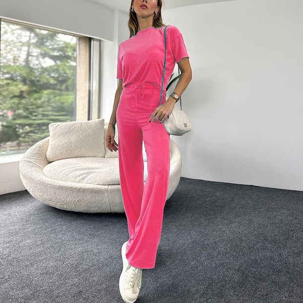 a woman in a pink jumpsuit standing in a living room