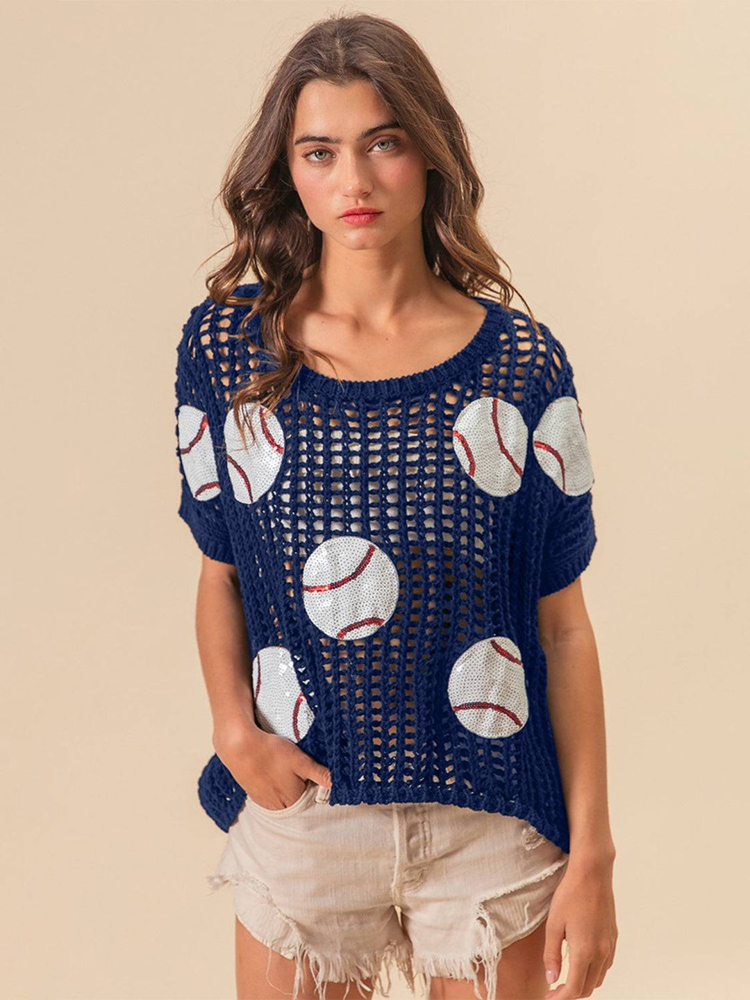 a woman wearing a blue sweater with baseballs on it