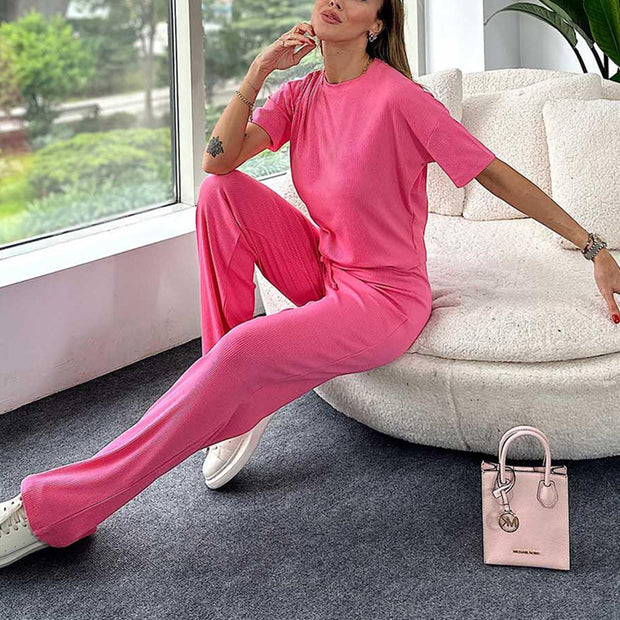 a woman sitting on a couch in a pink outfit