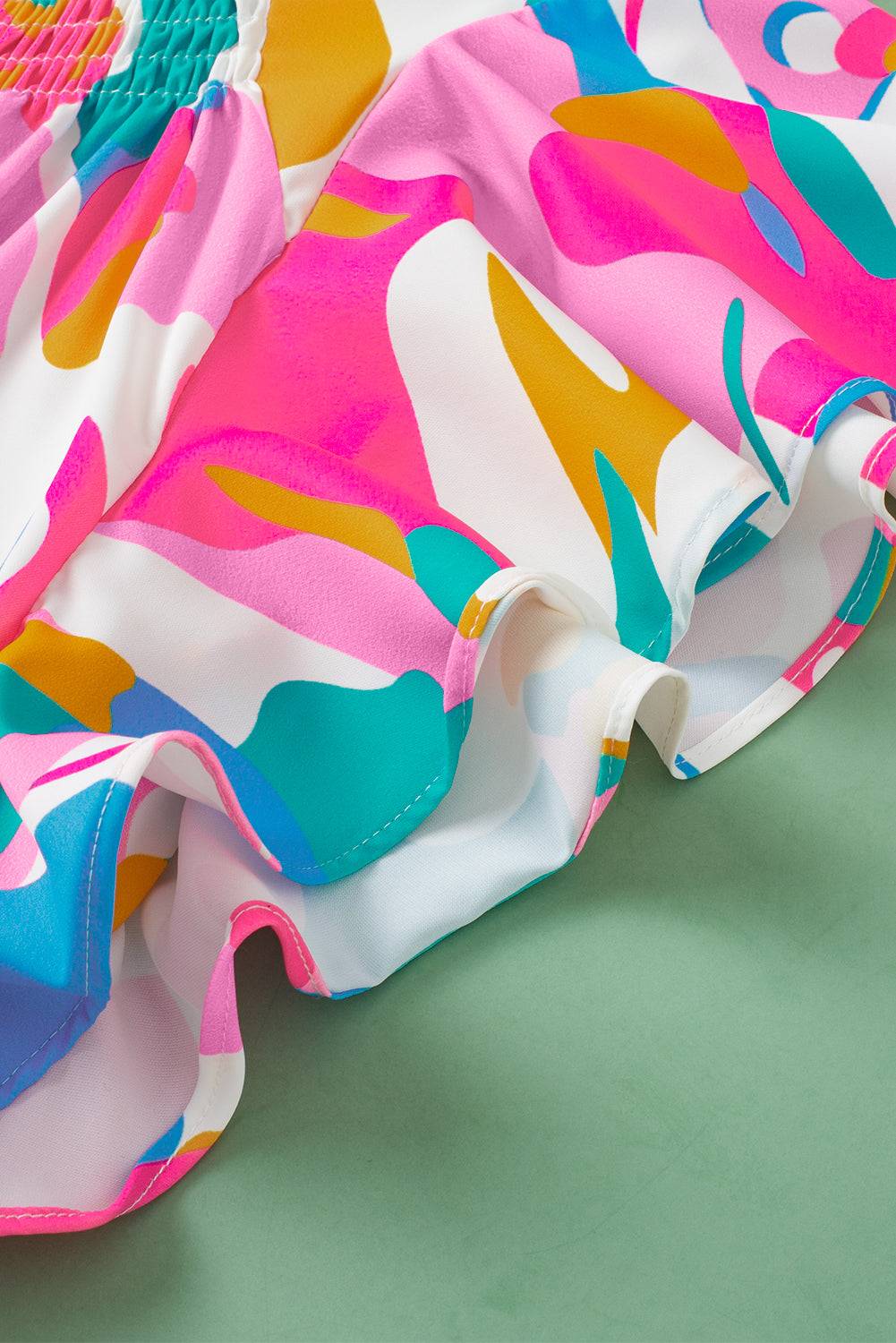 a close up of a pink, blue, yellow and green dress