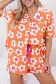 a woman in an orange and white flower print pajama set