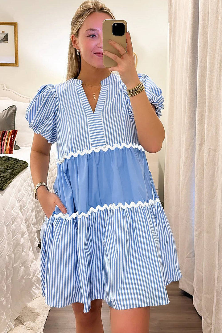 a woman taking a selfie in a blue and white dress