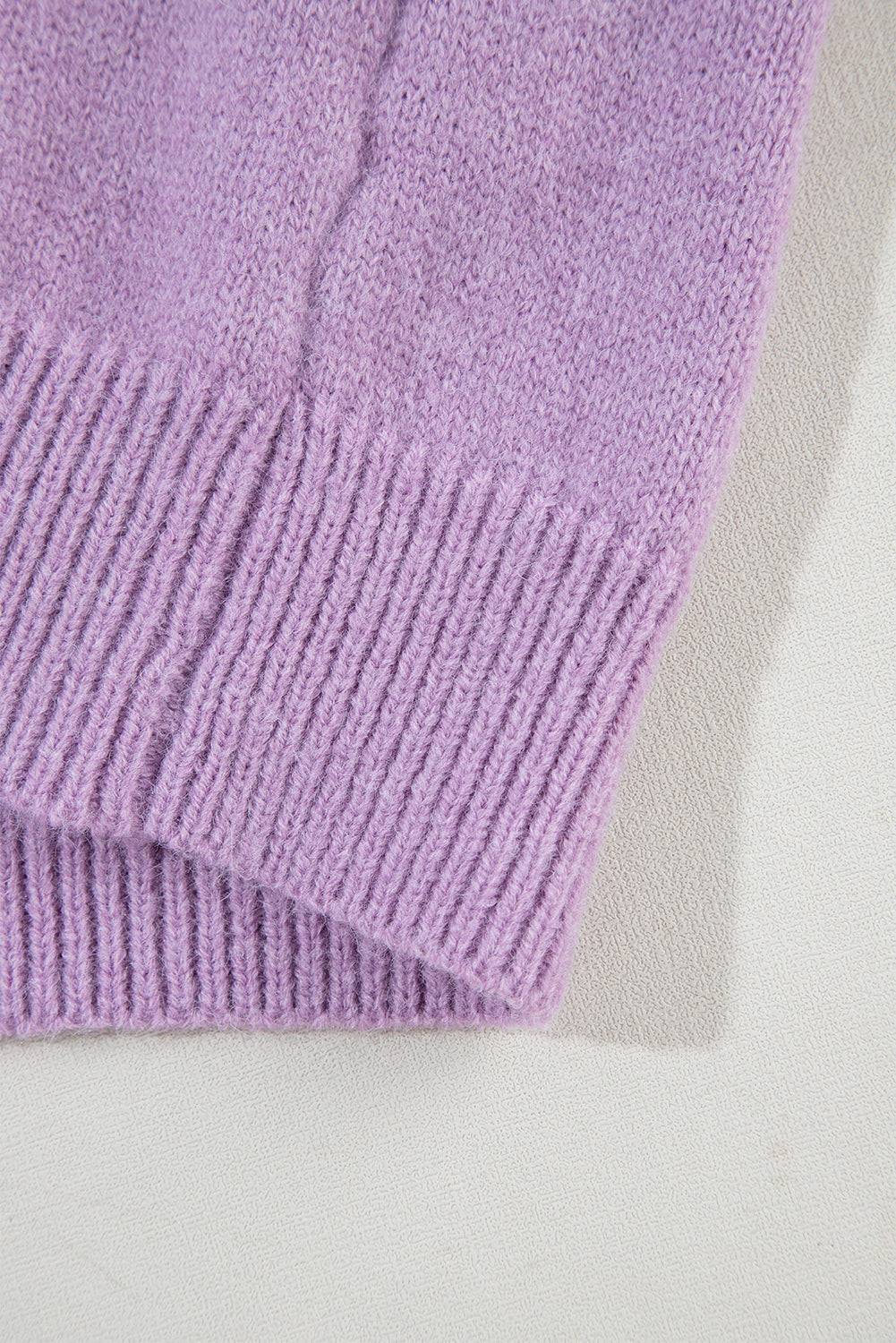 a close up of a purple sweater on a white surface