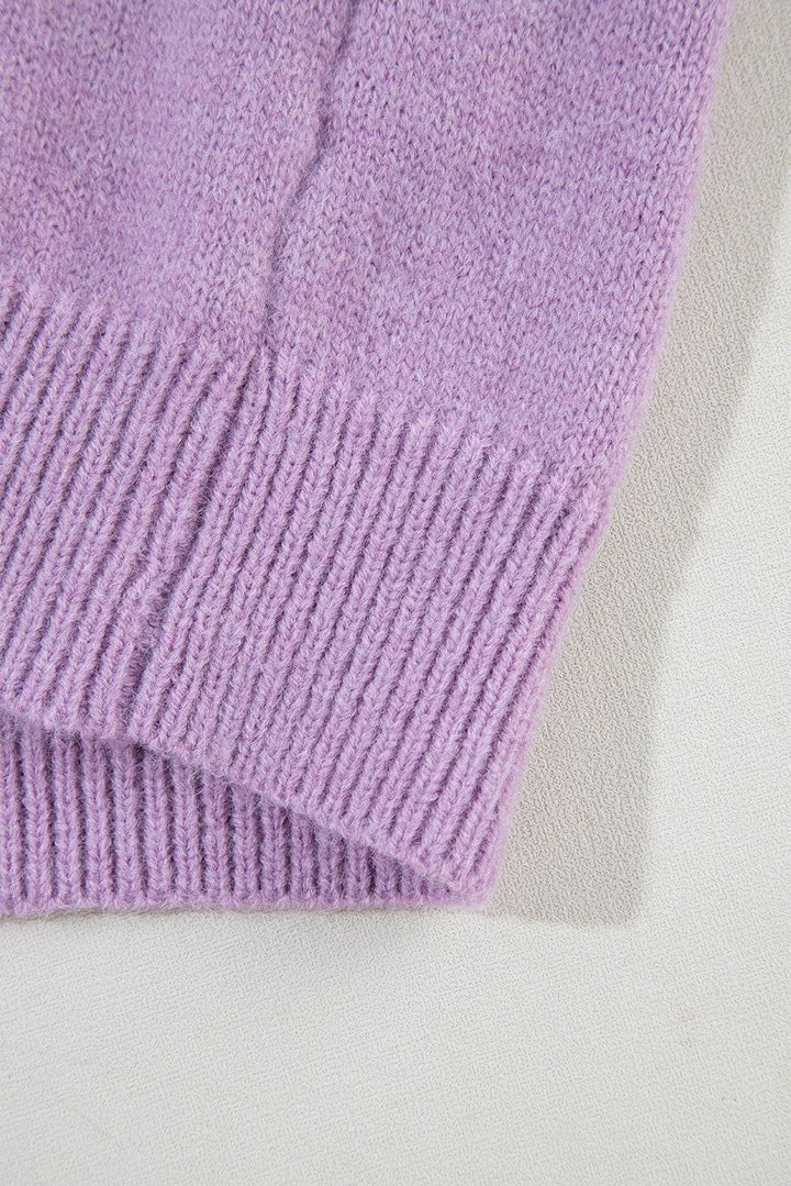 a close up of a purple sweater on a white surface