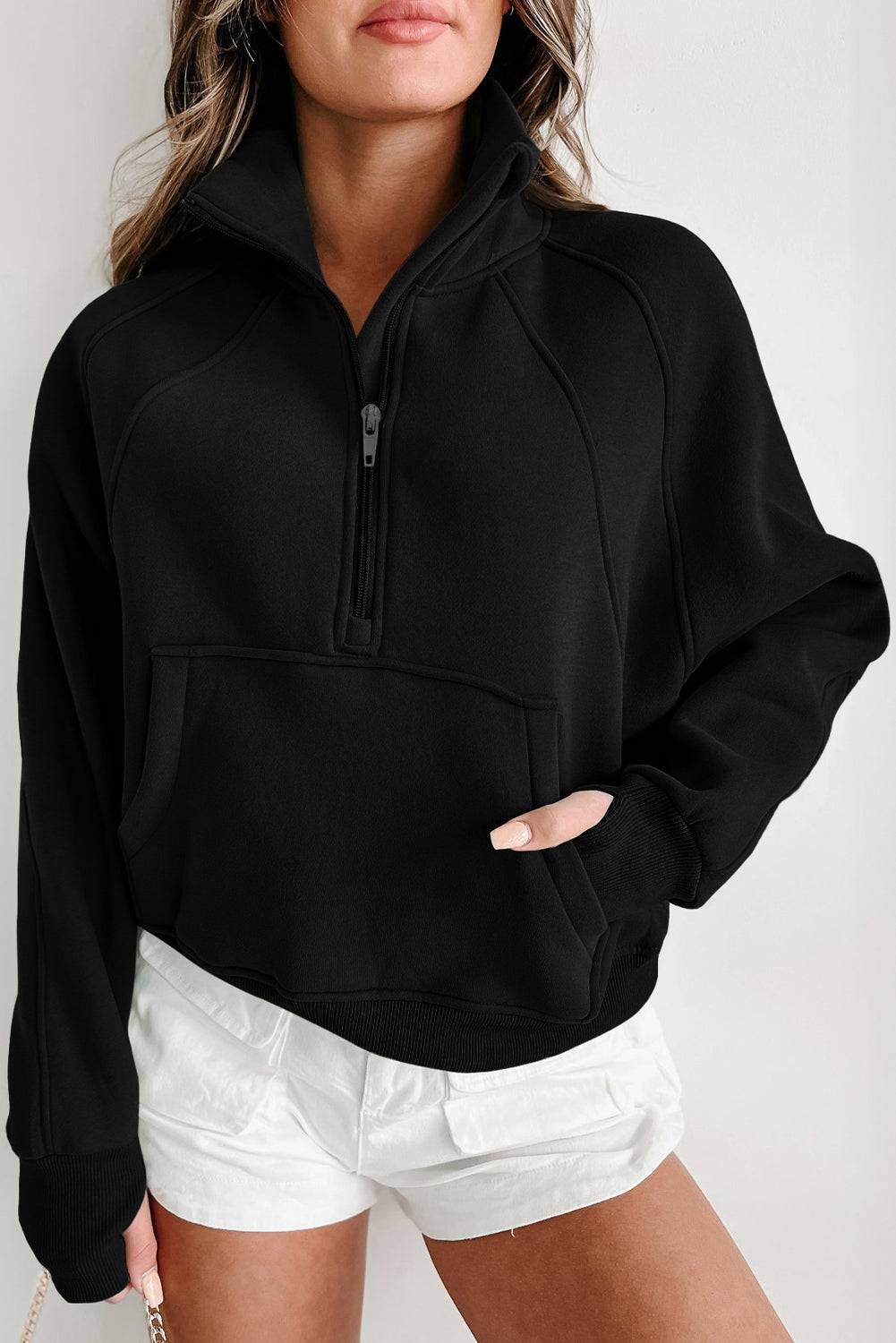 a woman wearing a black sweatshirt and white shorts