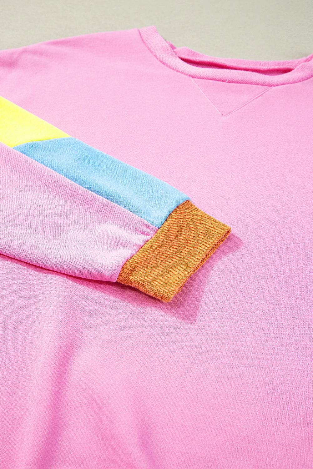 a pink shirt with a yellow and blue strip on it