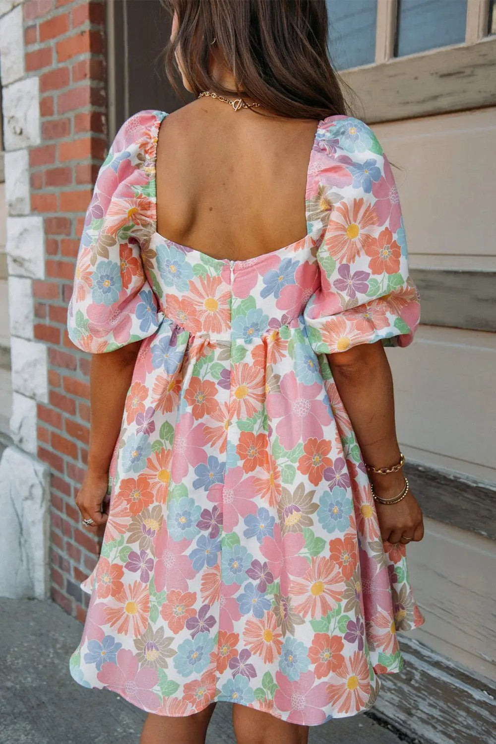 a woman wearing a dress with flowers on it