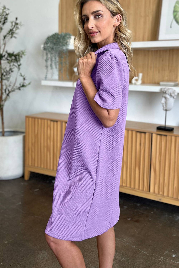 a woman in a purple dress posing for a picture