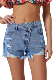 a woman wearing a floral top and denim shorts