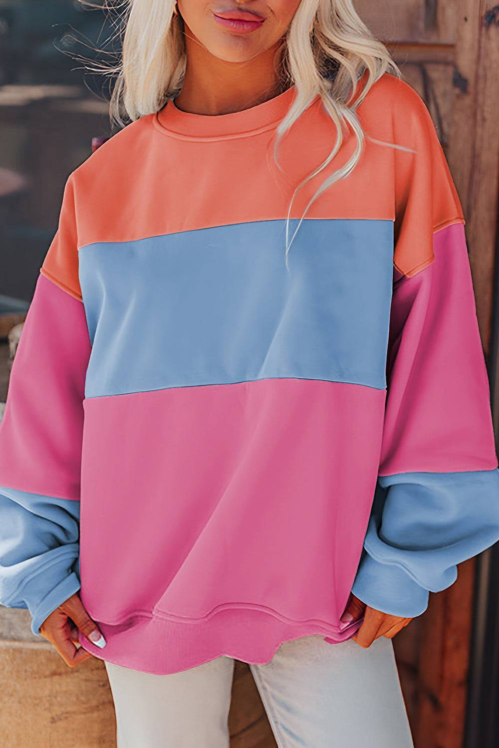 a woman wearing a pink, blue, and orange sweatshirt