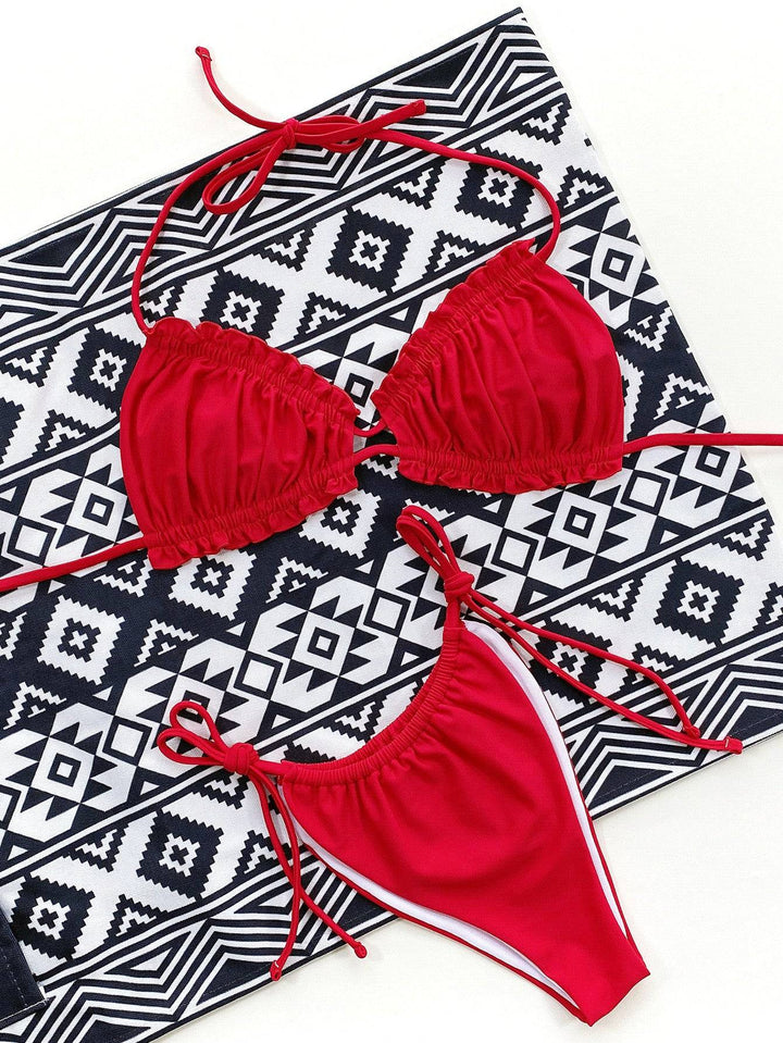 a red and white bikini top and a black and white towel