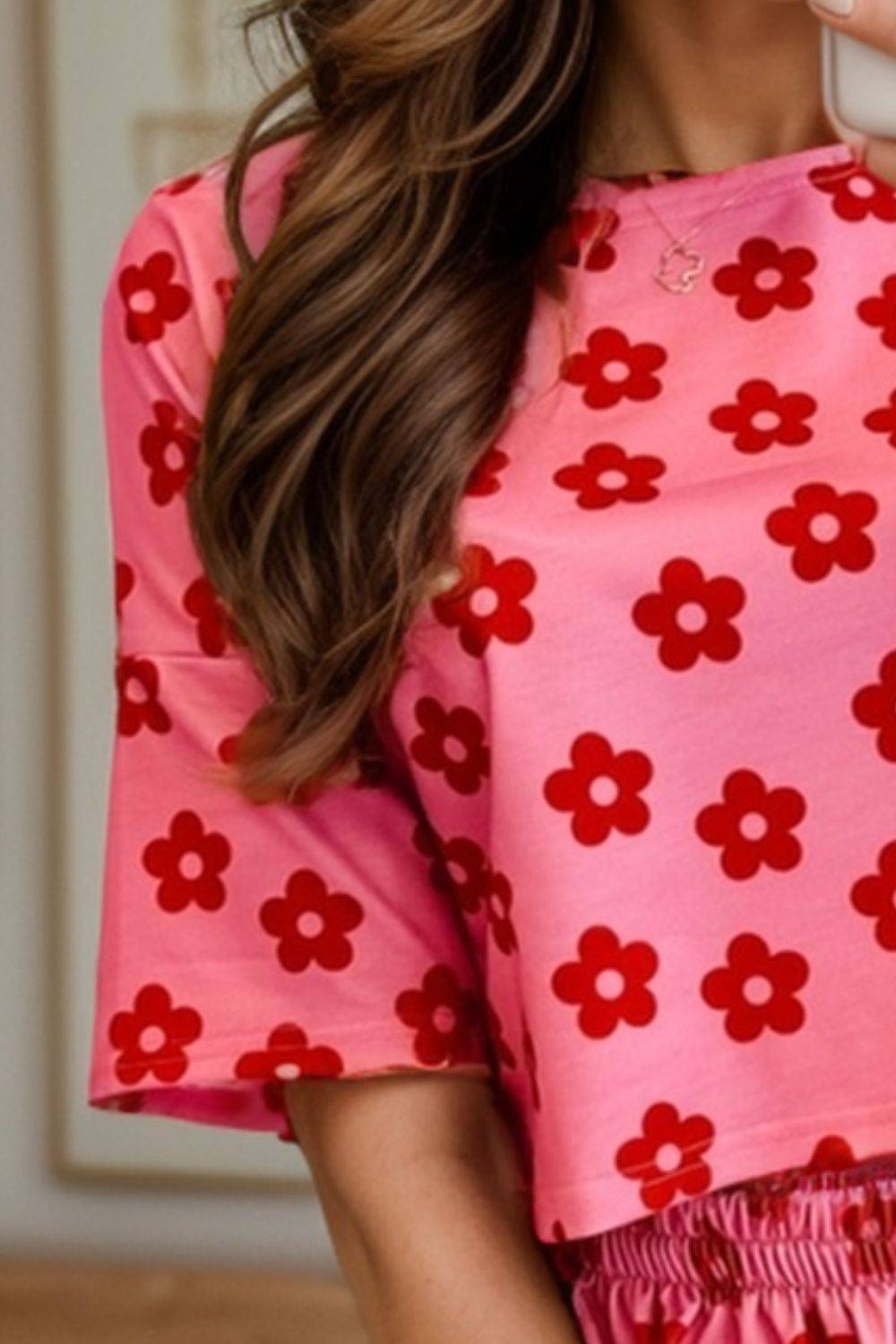 a woman in a pink dress holding a cell phone