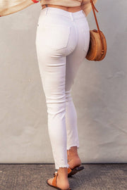 a woman in white jeans is holding a purse