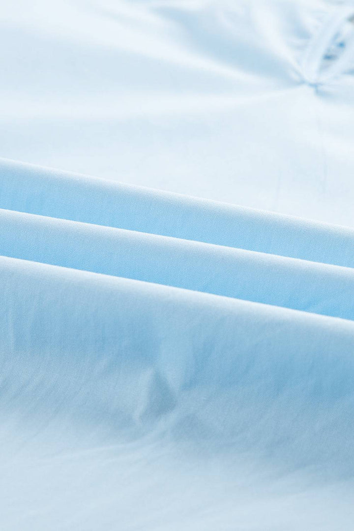 a close up of a blue sheet on a bed