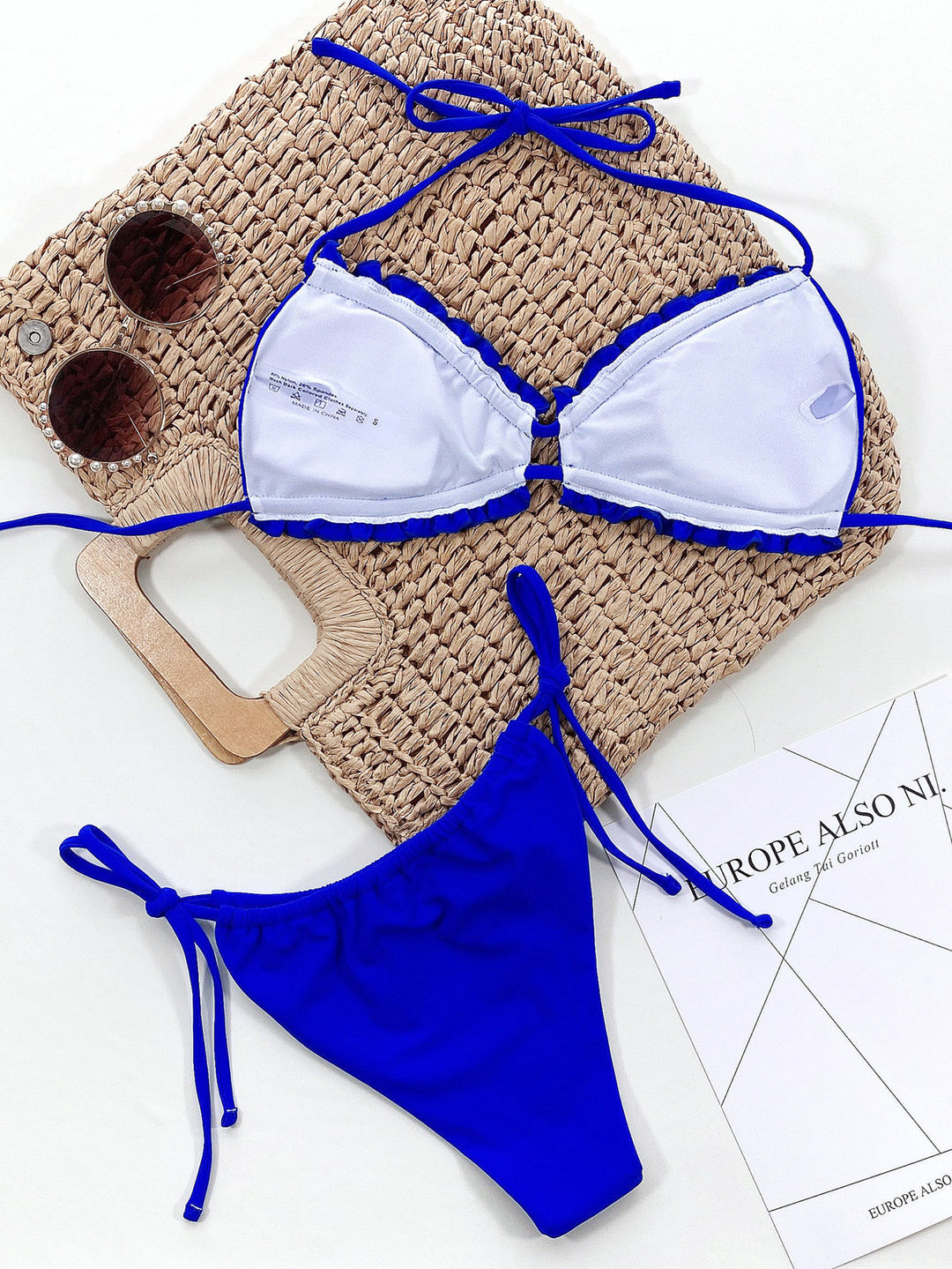 a blue and white bikini top and a pair of sunglasses
