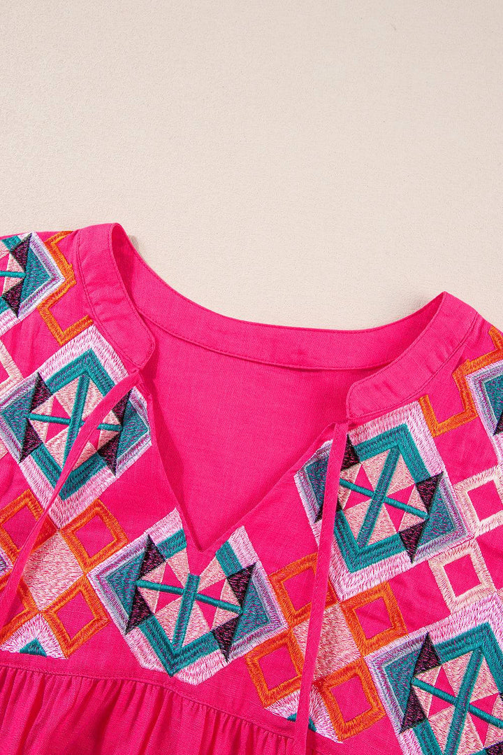 a close up of a pink dress with a design on it