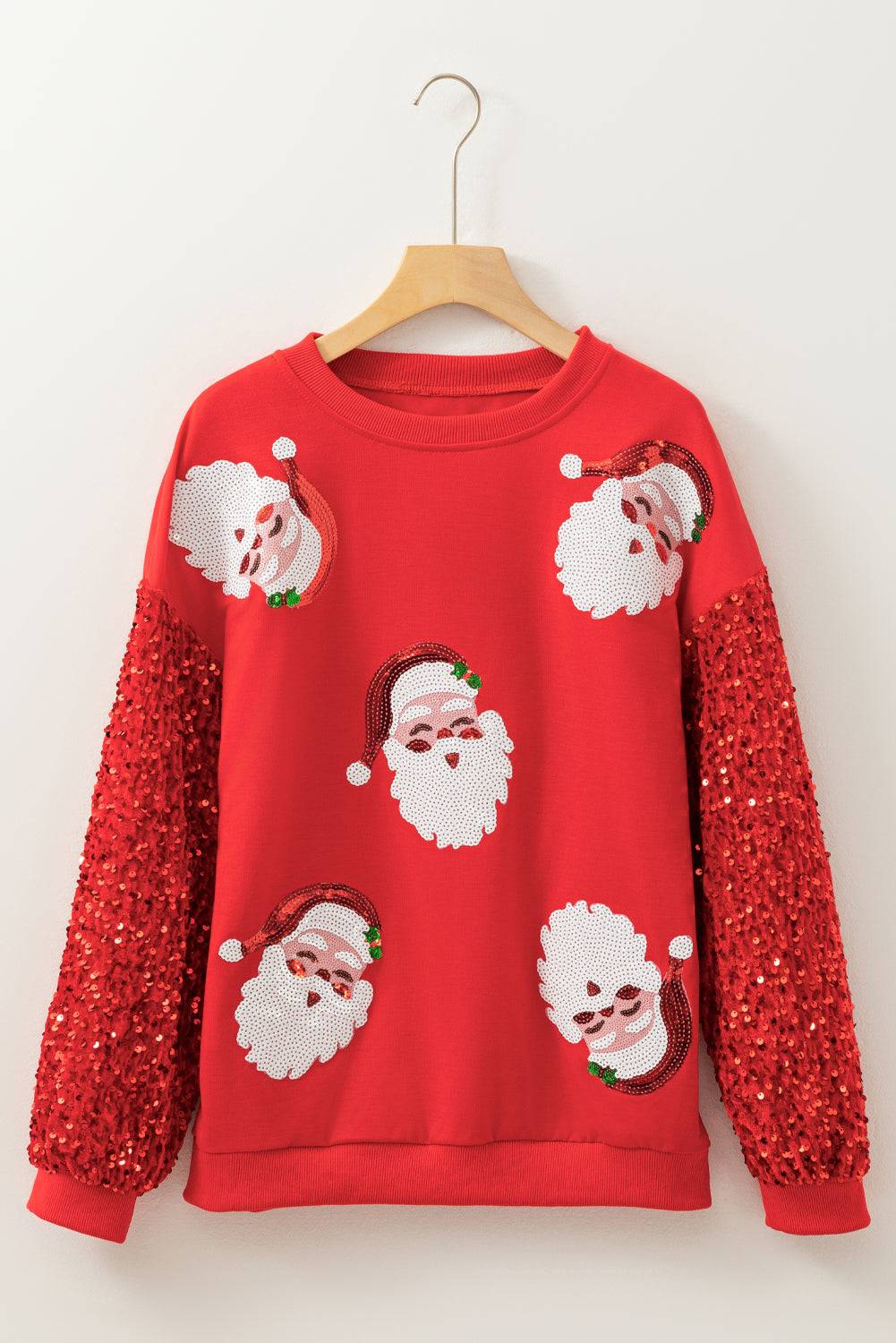 Red Moonlight Jade Christmas sweatshirt on hanger featuring sequin Santa faces and glitter sleeves, festive apparel from Faith & Co. Boutique.