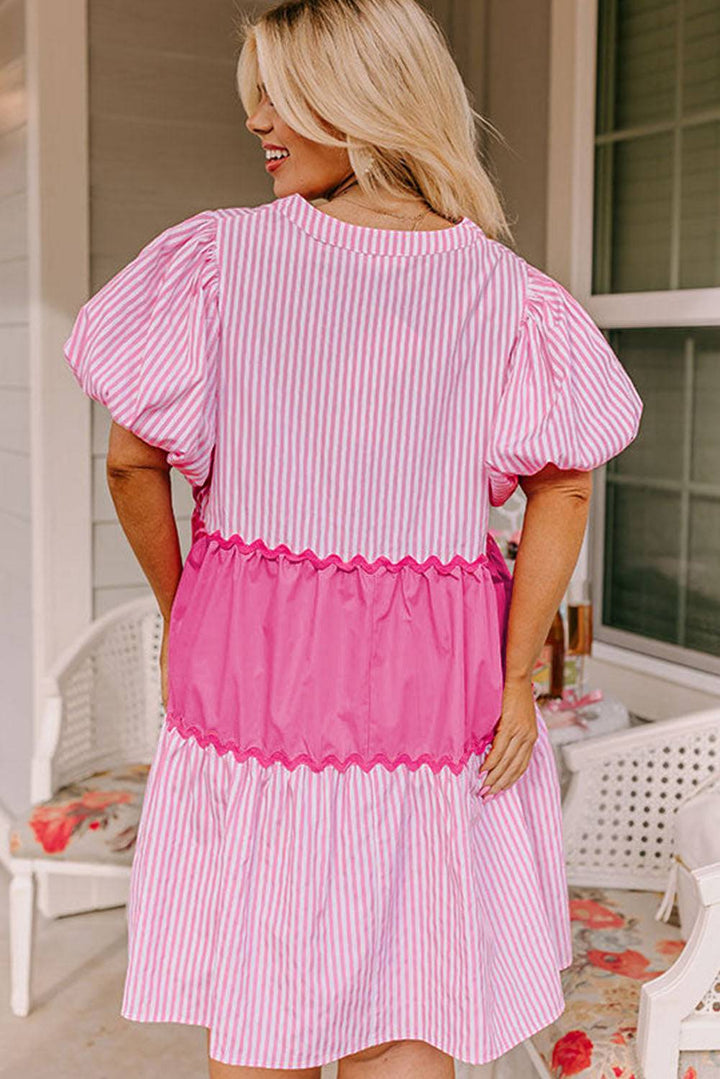 a woman wearing a pink and white striped dress