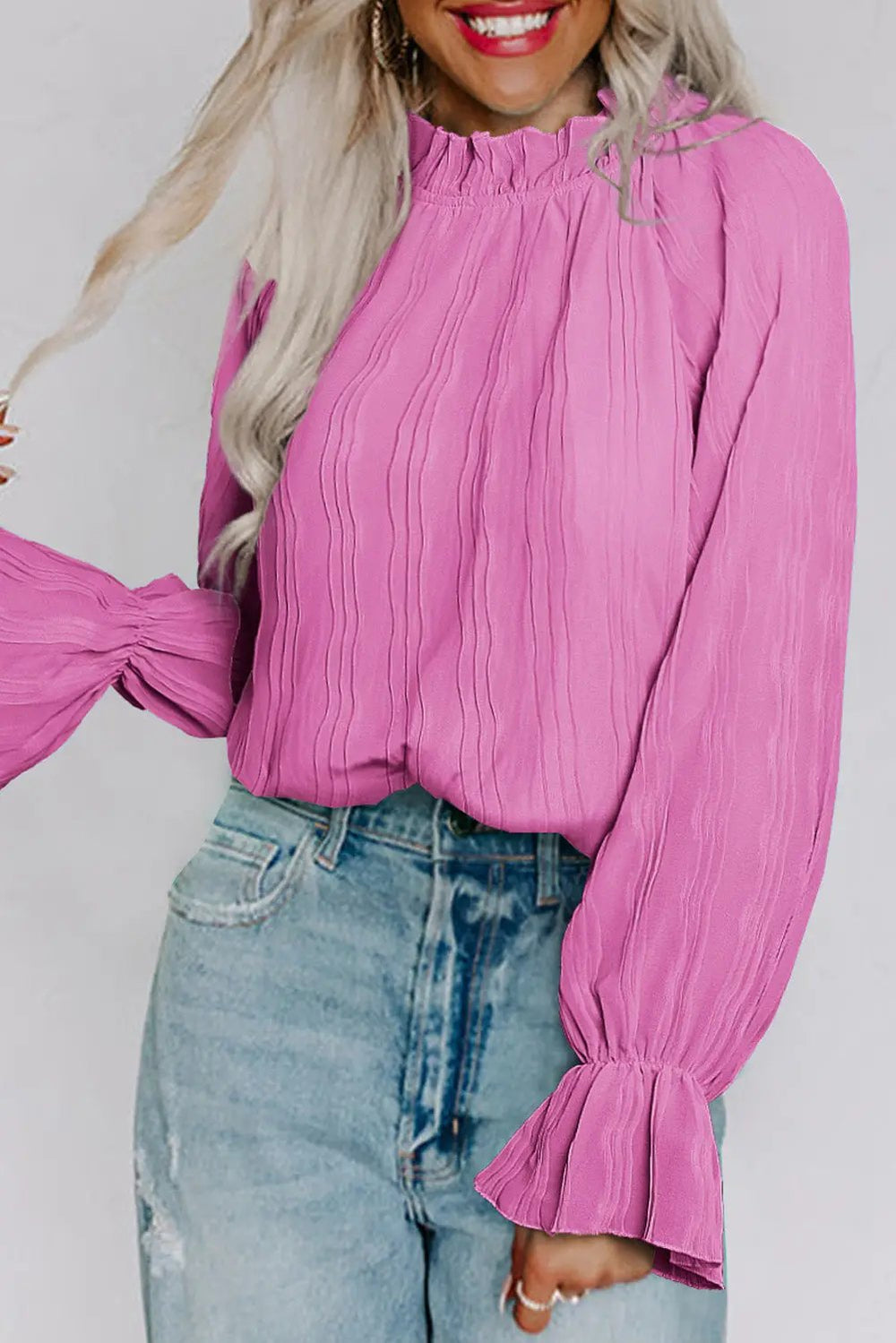 a woman wearing a pink blouse and jeans