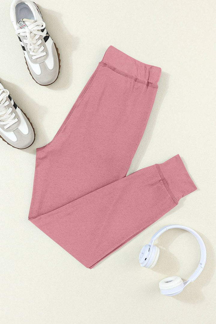 a pair of pink pants and headphones on a white surface