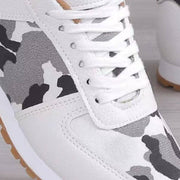 a pair of white sneakers with camouflage print