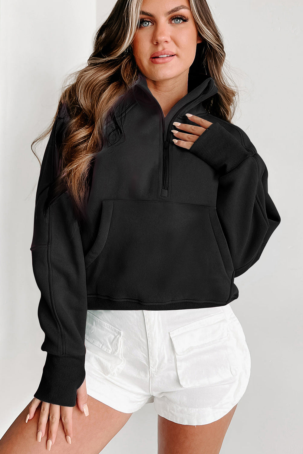 a woman wearing a black sweatshirt and white shorts