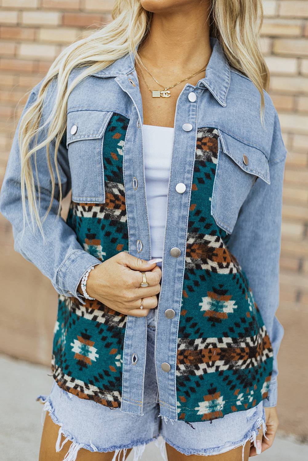 a woman wearing a denim jacket and shorts