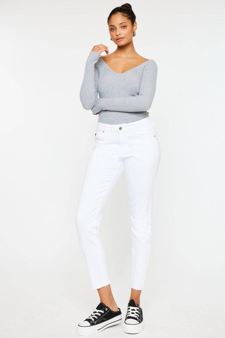 a woman wearing white jeans and a grey sweater