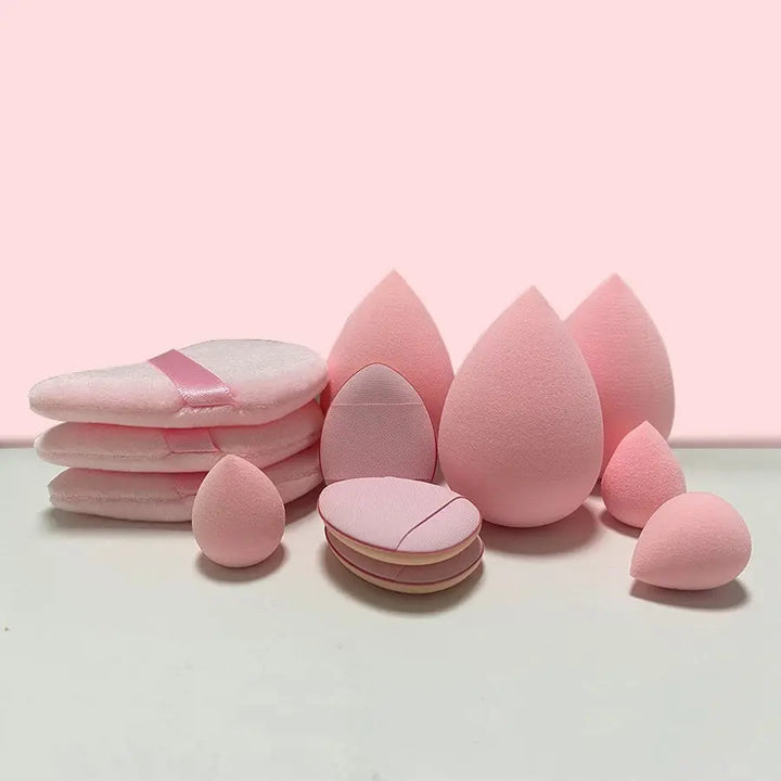 a pile of pink makeup sponges on a white surface